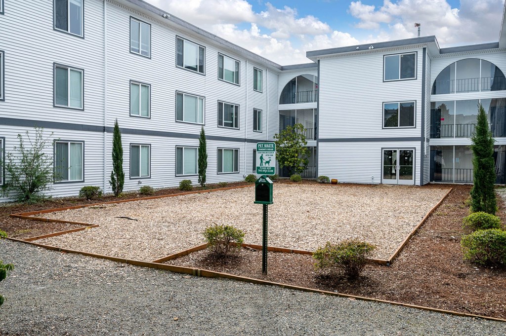 an empty parking lot in front of an apartment building